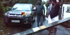 ഒടിഞ്ഞുവീണ വൈദ്യുത പോസ്റ്റിൻ്റെയും കടപുഴകിയ മരത്തിൻ്റെയും ഇടയിൽപ്പെട്ട് കാർ; എം എൽ എയ്ക്ക് തലനാരിഴയ്ക്ക് രക്ഷ
